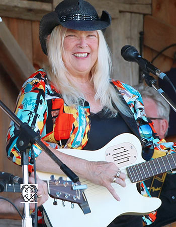 Joan playing a white guitar